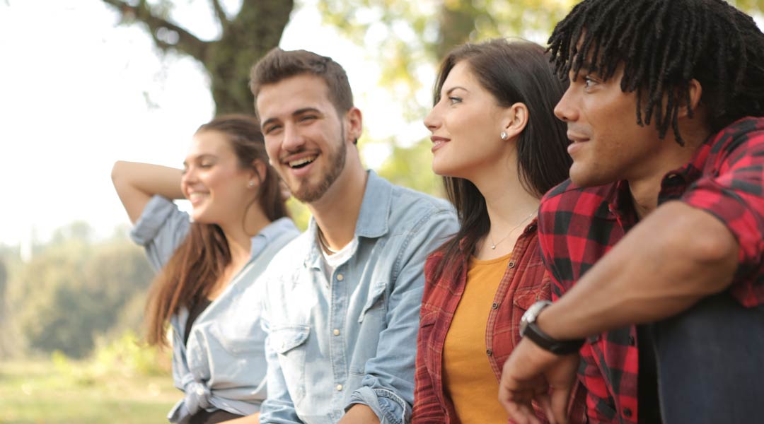 Photo of a diverse group of young people sitting together outside